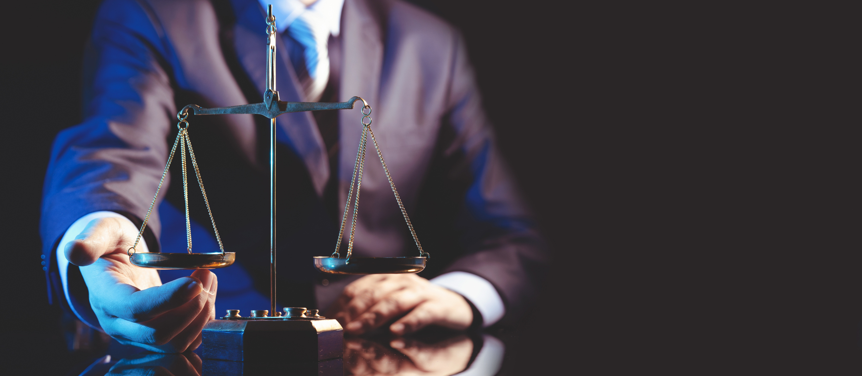 Lawyer and a Scale of Justice on Black Background